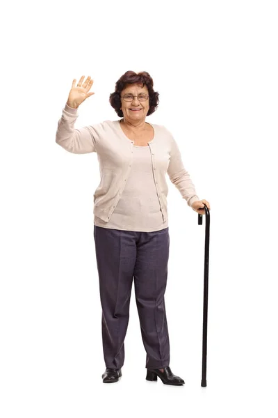 Пожилая женщина с тростью, машущей рукой — стоковое фото