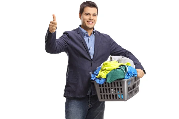 Homem com uma cesta cheia de roupas fazendo um gesto de polegar — Fotografia de Stock