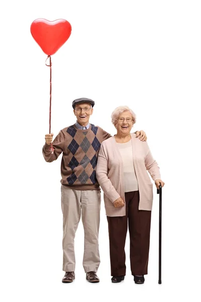 Elderly couple with a heart shaped balloon — Stock Photo, Image