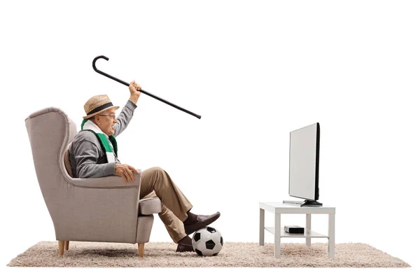 Ventilador de fútbol en un sillón viendo la televisión — Foto de Stock