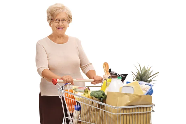 Donna con un carrello pieno di generi alimentari — Foto Stock