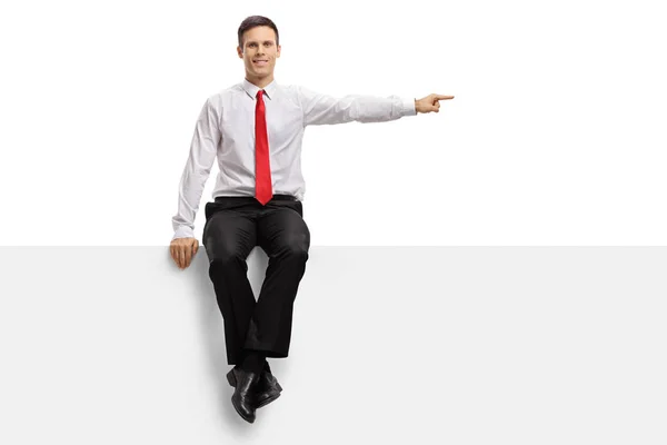 Guy sitting on a panel and pointing — Stock Photo, Image