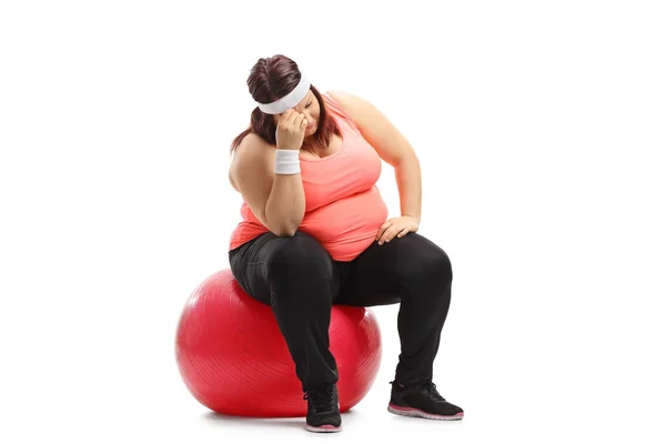 Triste mujer con sobrepeso sentada en una pelota de ejercicio — Foto de Stock