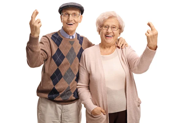 Elderly couple holding their fingers crossed — Stock Photo, Image