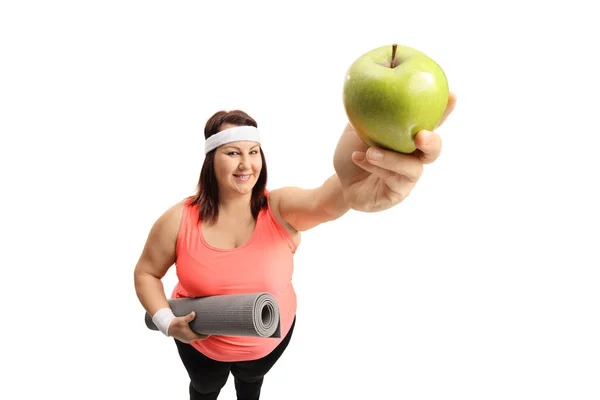 Übergewichtige Frau zeigt einen Apfel — Stockfoto