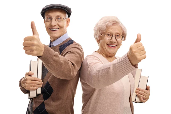 Senioren met boeken houden hun duimen omhoog — Stockfoto