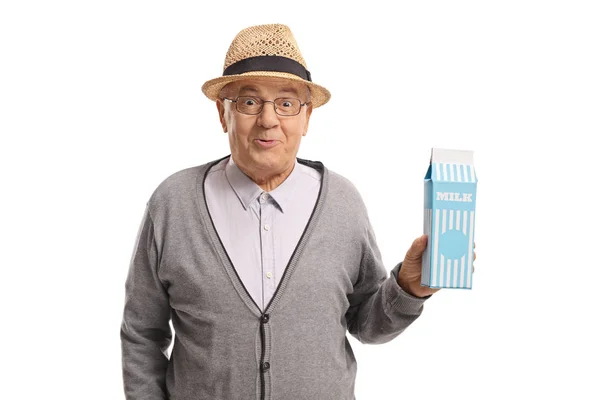Älterer Mann hält einen Karton Milch in der Hand — Stockfoto