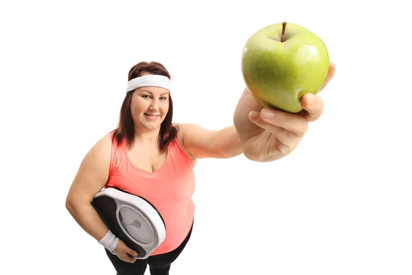 Mujer con sobrepeso con una escala de peso y una manzana —  Fotos de Stock