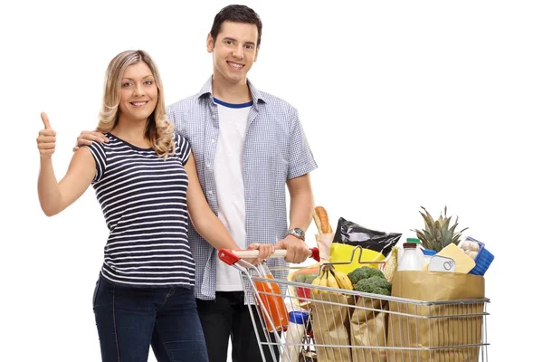 Paar mit einem Einkaufswagen mit Lebensmitteln macht eine Daumen-hoch-Geste — Stockfoto