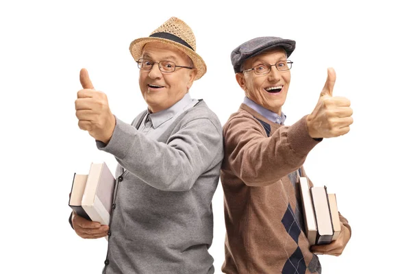 Mannen met boeken making duim omhoog gebaren — Stockfoto