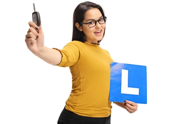 Flicka som håller en bilnyckel och en L-sign — Stockfoto