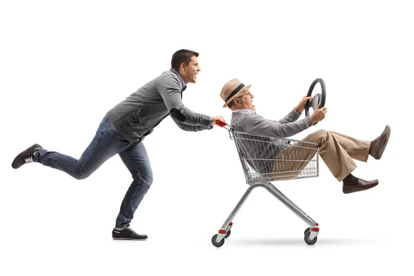 Мужчина толкает шопинг-картонку со зрелым мужчиной — стоковое фото