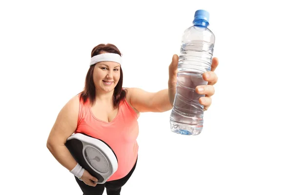 Bir ağırlık ölçeği ve bir su şişesi tutan kadın — Stok fotoğraf