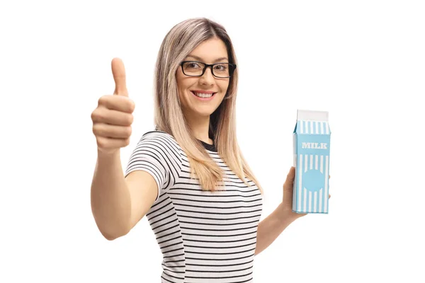Женщина держит коробку молока и делает большой палец вверх вывеску — стоковое фото
