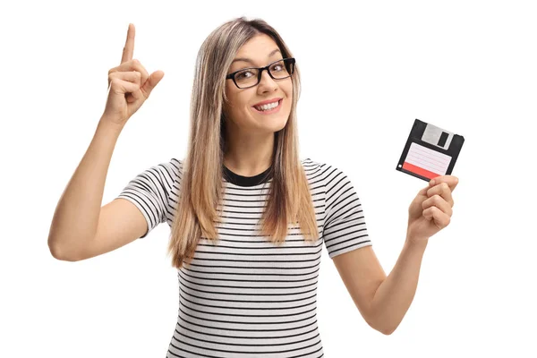 Mulher com um disquete segurando seu dedo indicador para cima — Fotografia de Stock