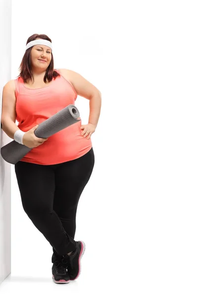Mujer con sobrepeso con una esterilla de ejercicio — Foto de Stock