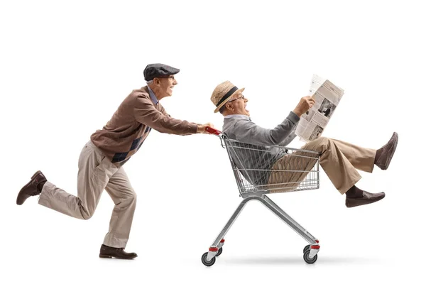 Senior empujando un carrito de compras con otro senior — Foto de Stock