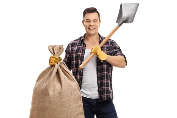 Boer holding een jute zak en een schop — Stockfoto