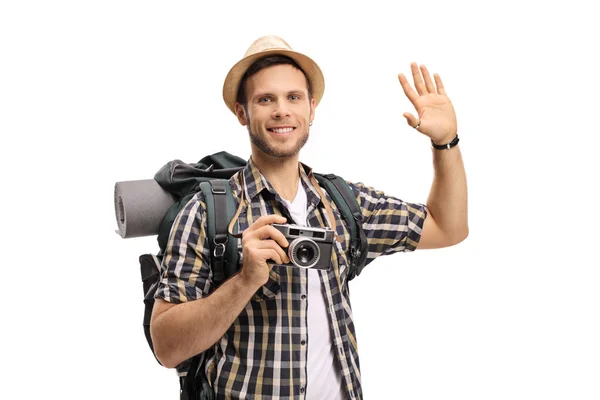 Turista com uma câmera e uma mochila acenando — Fotografia de Stock