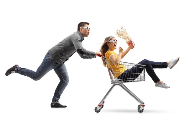 Frau fährt in Einkaufswagen und wird von Mann geschubst — Stockfoto