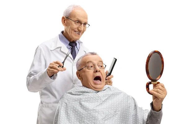 Senior blickt beim Friseur im Spiegel auf seine Frisur — Stockfoto