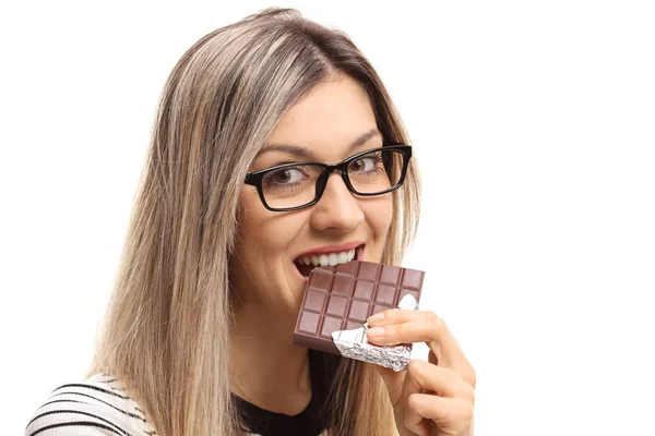 Mulher dando uma mordida fora de uma barra de chocolate — Fotografia de Stock