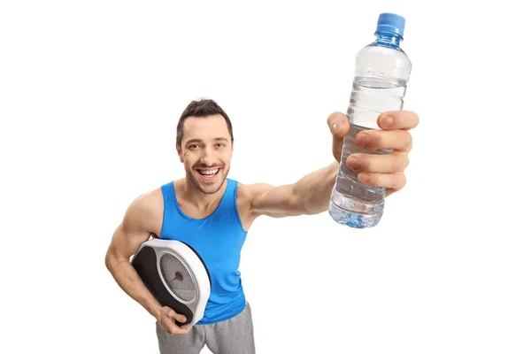 Ο τύπος κρατάει μια κλίμακα βάρους και ένα μπουκάλι νερό — Φωτογραφία Αρχείου
