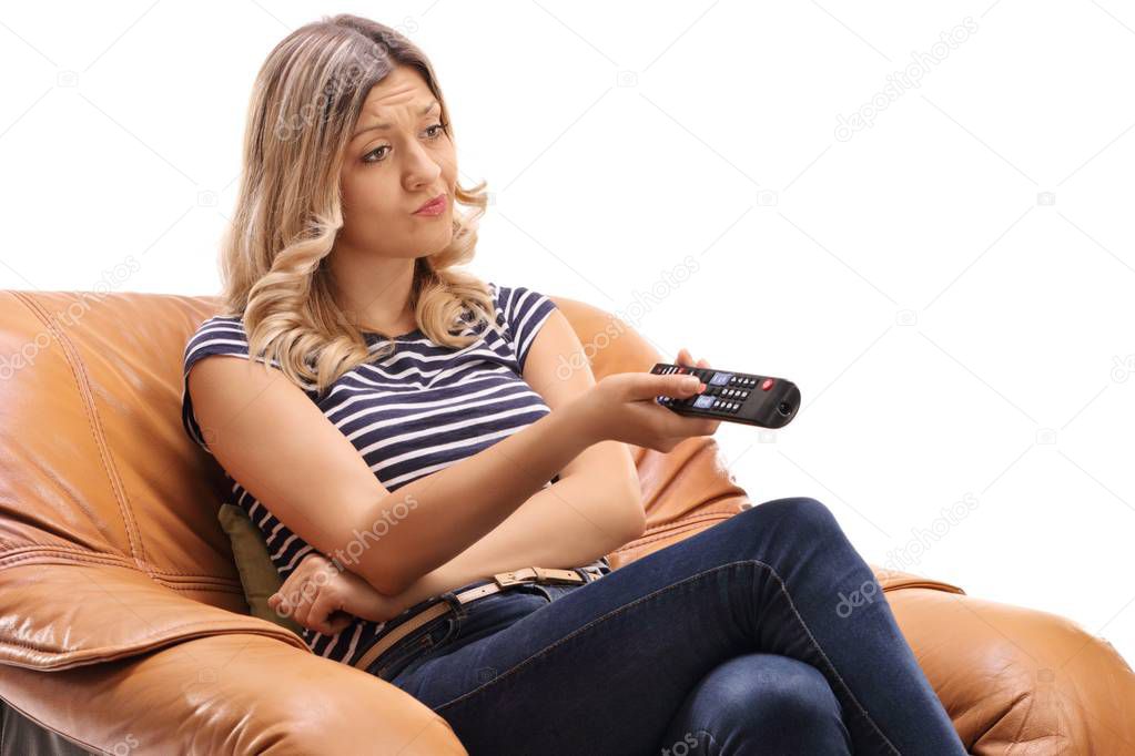 Bored woman watching television in an armchair