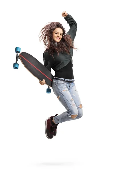 Overjoyed teen girl with a longboard jumping — Stock Photo, Image