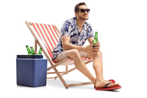 Tourist sitting in a deck chair next to a cooling box — Stock Photo, Image