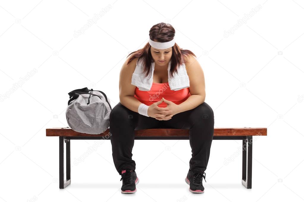 woman sitting on a bench next to a sports bag