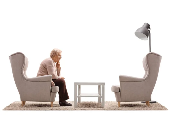 Bir koltukta oturan üzgün ve yalnız kadın — Stok fotoğraf