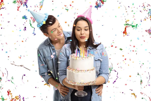 Couple avec un gâteau d'anniversaire et des banderoles confettis — Photo