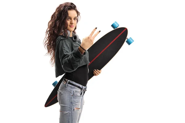 Ragazza con un longboard fare un gesto di pace — Foto Stock