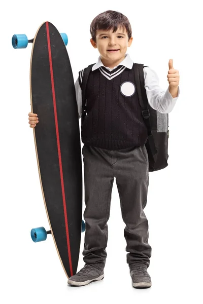 Schoolboy with a longboard making a thumb up sign — Stock Photo, Image