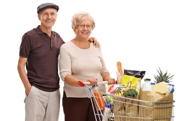 Couple with a shopping cart filled with groceries — Stock Photo, Image
