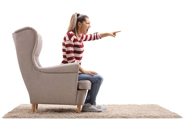 Angry woman sitting in an armchair and arguing — Stock Photo, Image