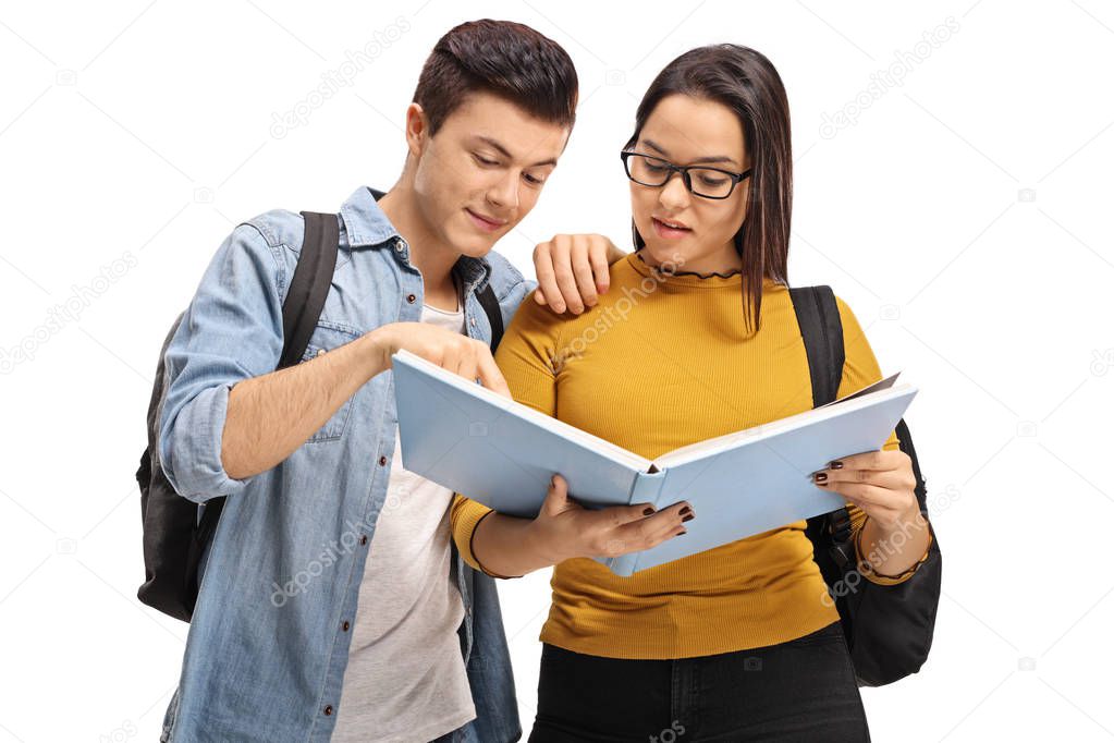 Teenage students reading a book together