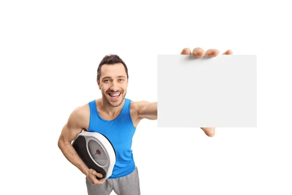 Man holding a weight scale and showing a blank card — Stock Photo, Image