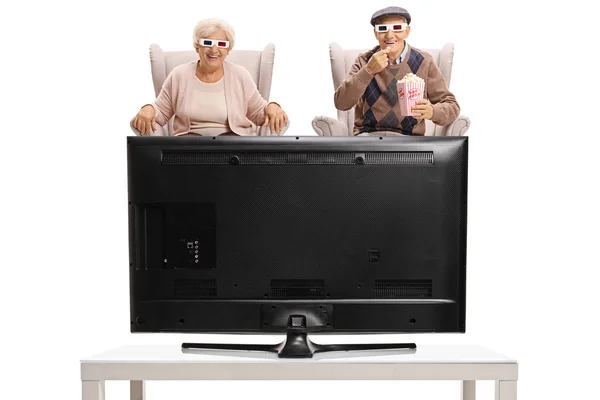 Senioři s 3d brýlemi a popcorn, sledování televize — Stock fotografie