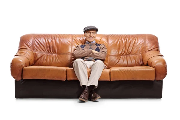 Senior sitzt auf einem Ledersofa — Stockfoto