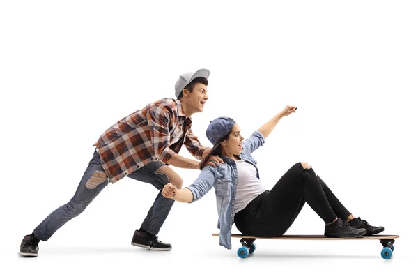 Menino empurrando uma menina em um longboard — Fotografia de Stock