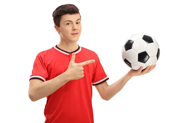 Voetballer holding een voetbal en wijzen — Stockfoto