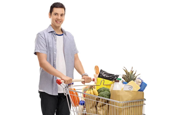Hombre con un carrito de compras lleno de comestibles —  Fotos de Stock