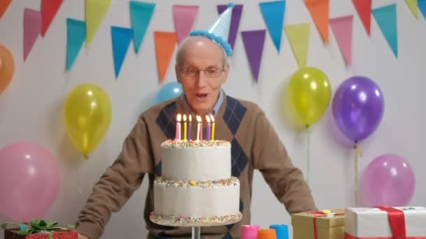 誕生日ケーキのろうそくを吹き 親指ジェスチャーを作る元気なシニア — ストック動画
