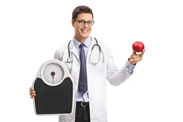 Doctor sosteniendo una báscula de peso y una manzana — Foto de Stock