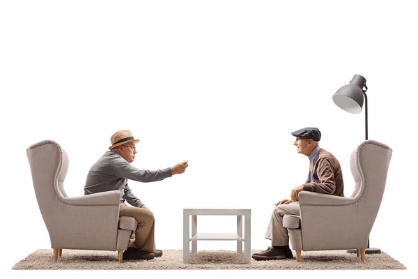 Seniors sitting in armchairs and talking — Stock Photo, Image