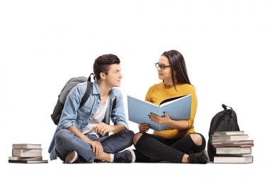 Genç öğrenciler yerdeki bir kitap okuma