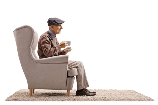 Senior z filiżanką, siedząc na fotelu — Zdjęcie stockowe