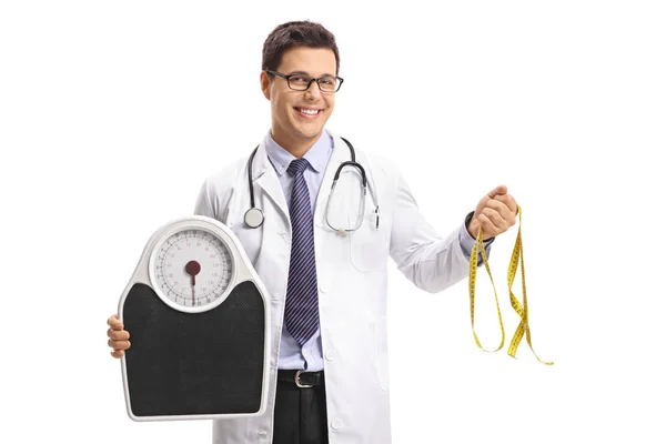 Médico segurando uma balança de peso e uma fita métrica — Fotografia de Stock